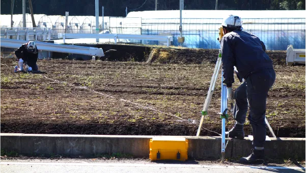現地で3D測量を行う作業員と測量機器